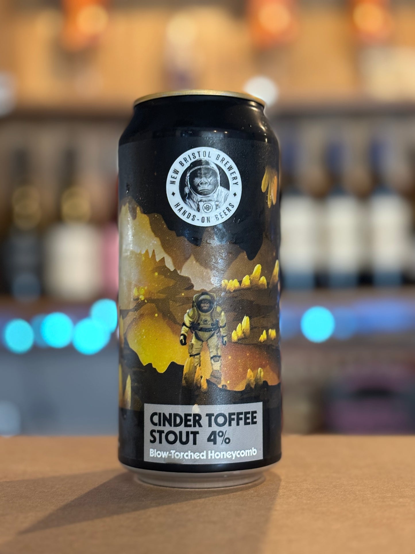 Cinder Toffee Stout can with astronaut graphic on a bar counter
