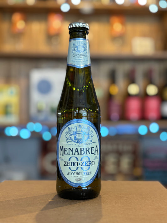 Menabrea Zero-Zero alcohol-free beer bottle on a bar counter with blurred shelves in the background