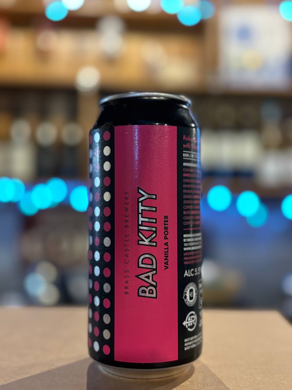 Can of Bad Kitty beer with a polka dot design on a bar counter
